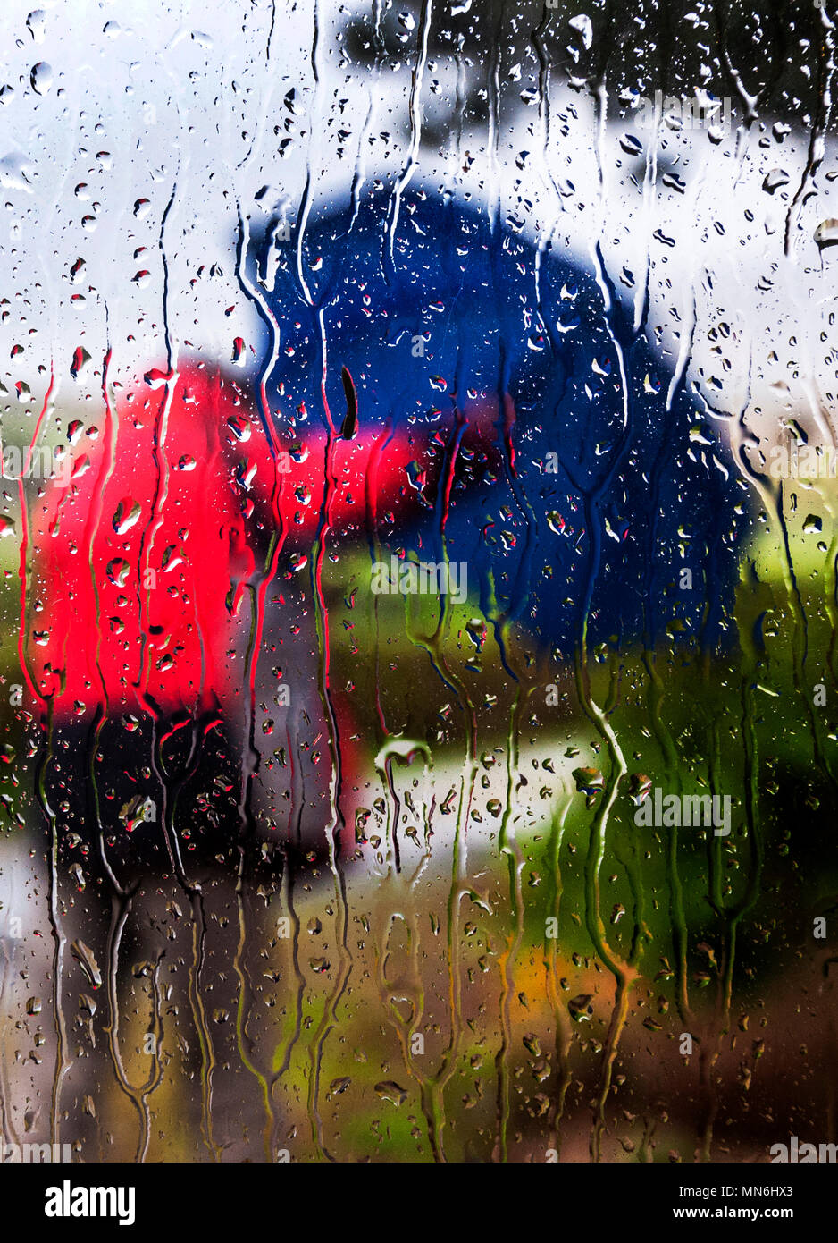 Rainy and windy day concept shot through rain spattered window pane Stock Photo