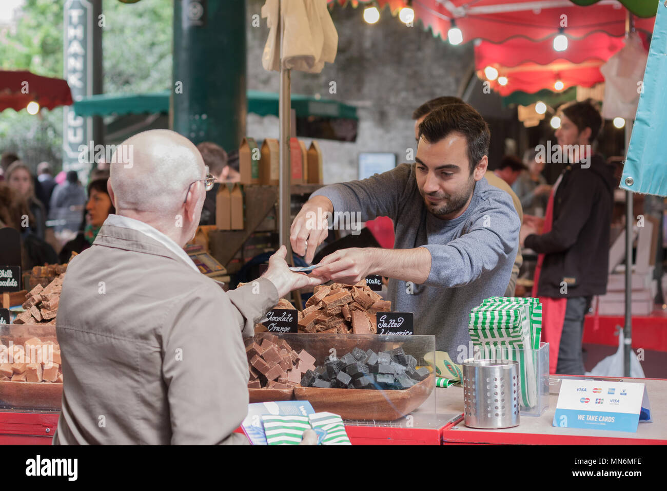 SOUTHWARK, LONDON-SEPTEMBER 7,2017: Man is selling chocolate pieces in stall at Borough Market on September 7, 2017 in London. Borough Market Stock Photo