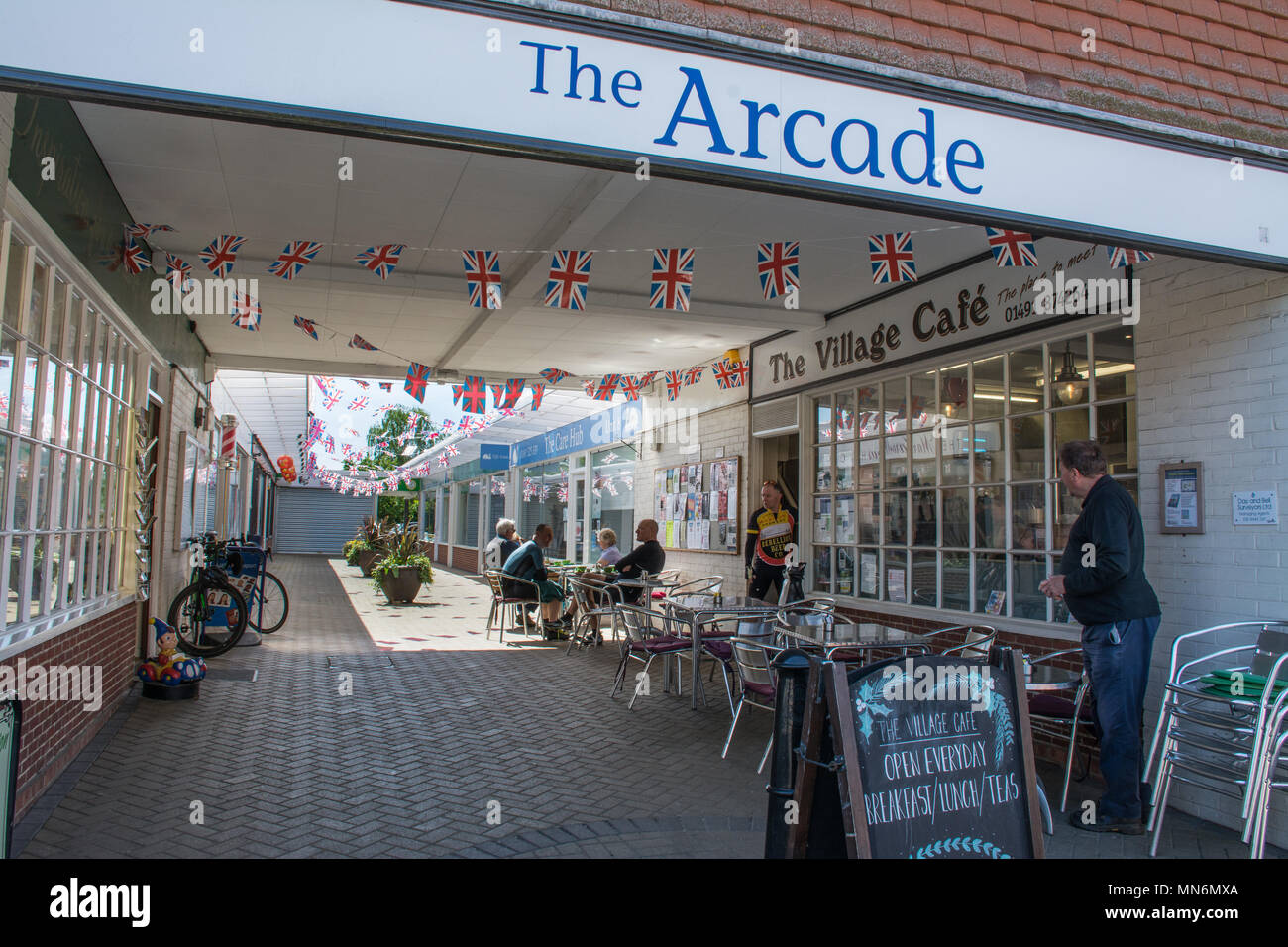 The Arcade off of the High Street in the village of Goring-on-Thames in Oxfordshire, UK, with people sitting at outside tables at a cafe Stock Photo