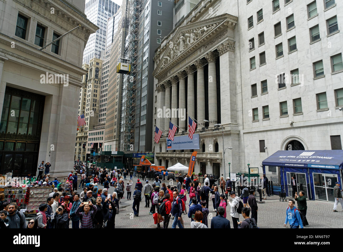 The intersection of Broad and Wall Streets in Manhattan’s Financial District is usually crowded with tourists, office workers and residents. Stock Photo