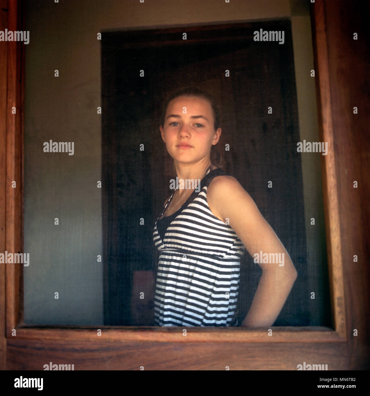 Half-Length Portrait of Teen Girl Framed by Door Stock Photo