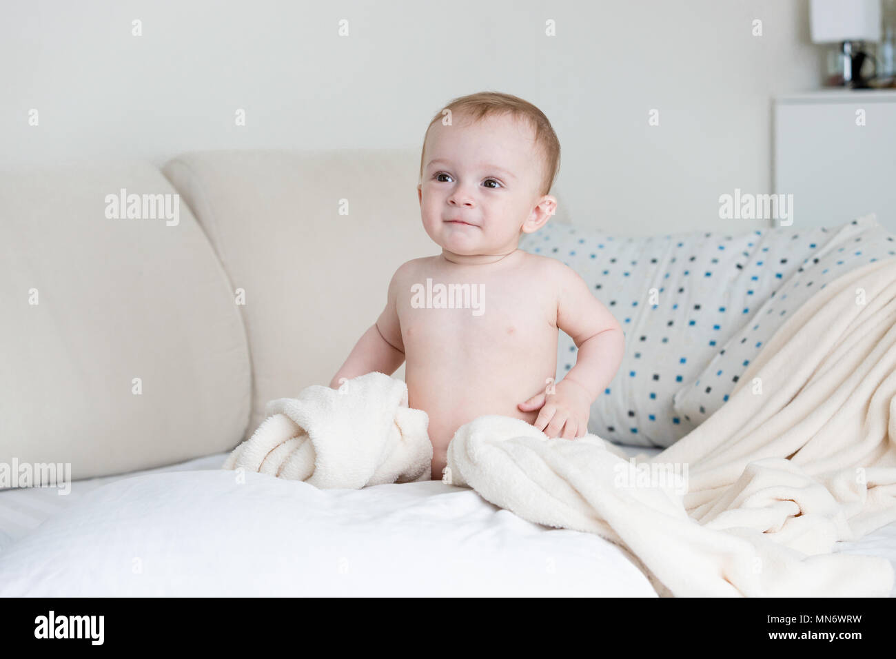 Laughing baby boy sitting on bed hi-res stock photography and images ...