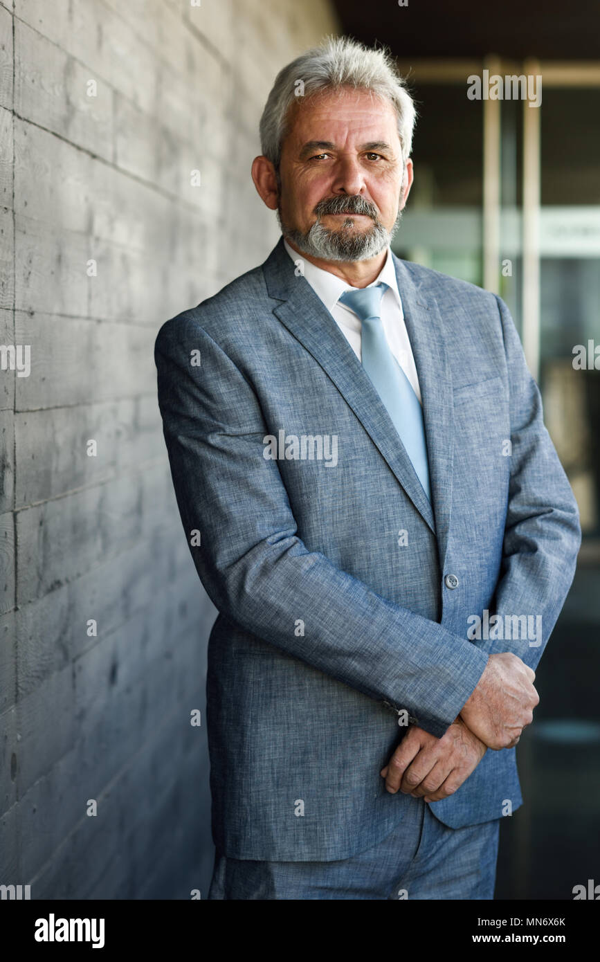 Portrait of a senior businessman with arms crossed outside of modern ...