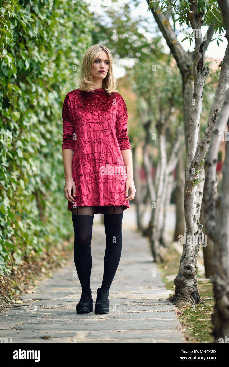 https://c8.alamy.com/comp/MN6XGD/beautiful-blonde-woman-in-urban-background-young-girl-wearing-red-dress-and-tights-standing-in-the-street-pretty-female-with-straight-hairstyle-and-blue-eyes-MN6XGD.jpg