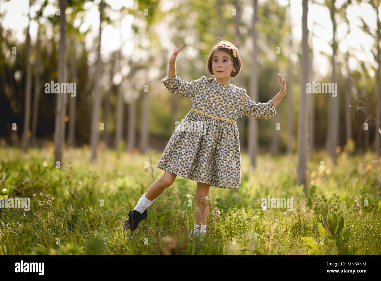 Little girl walking in nature field wearing beautiful dress Stock Photo ...
