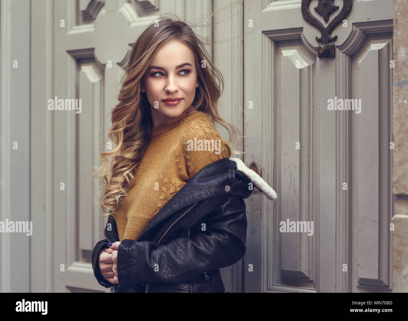 Blonde woman in urban background. Beautiful young girl wearing black ...