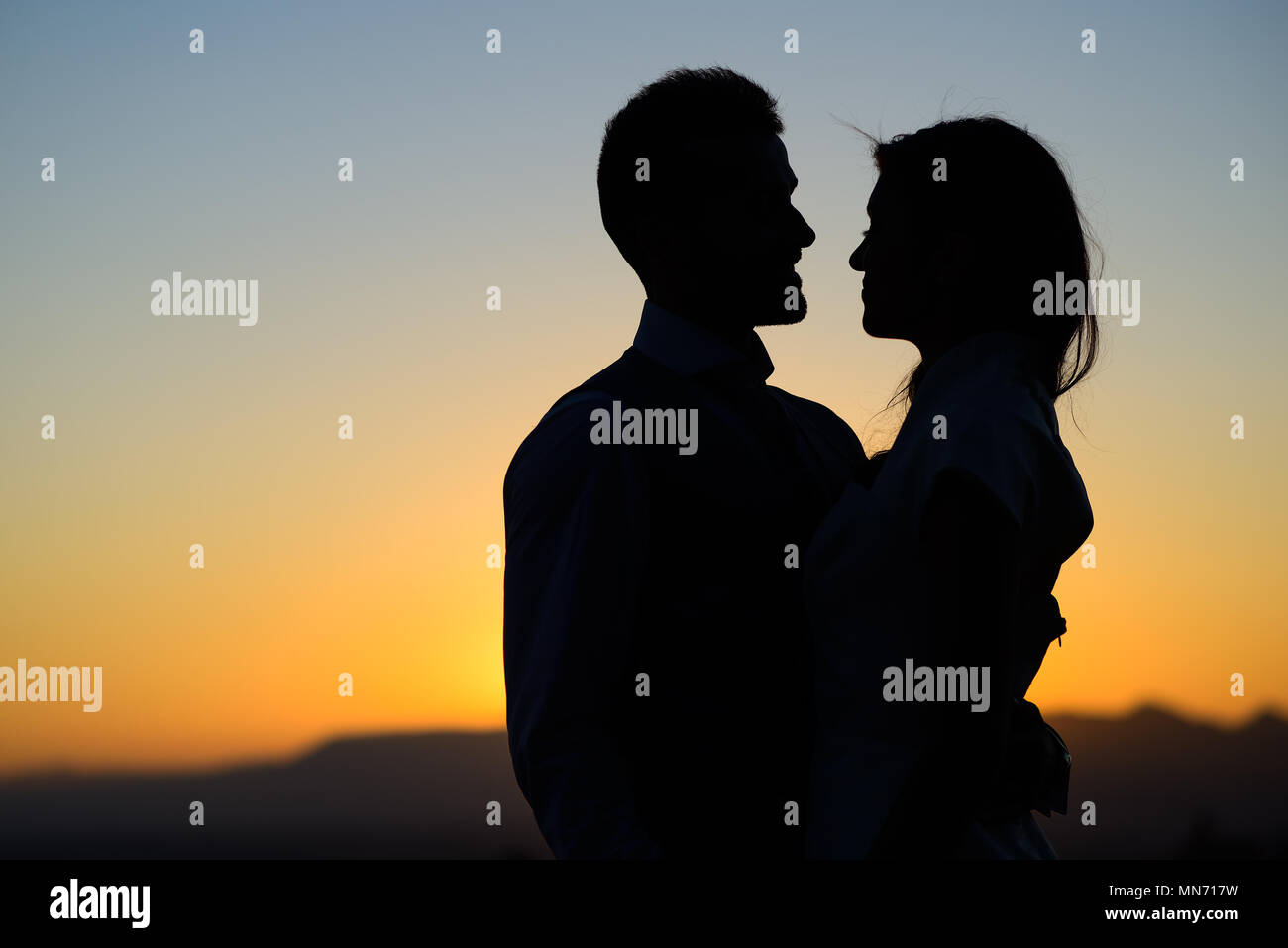 Silhouette of a young bride and groom on Sunset background Stock Photo ...