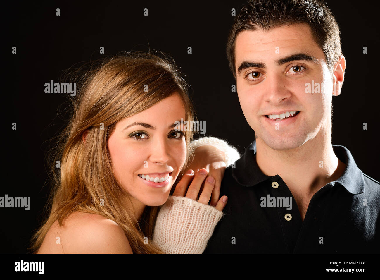Portrait of a happy couple smiling at camera on black background Stock ...