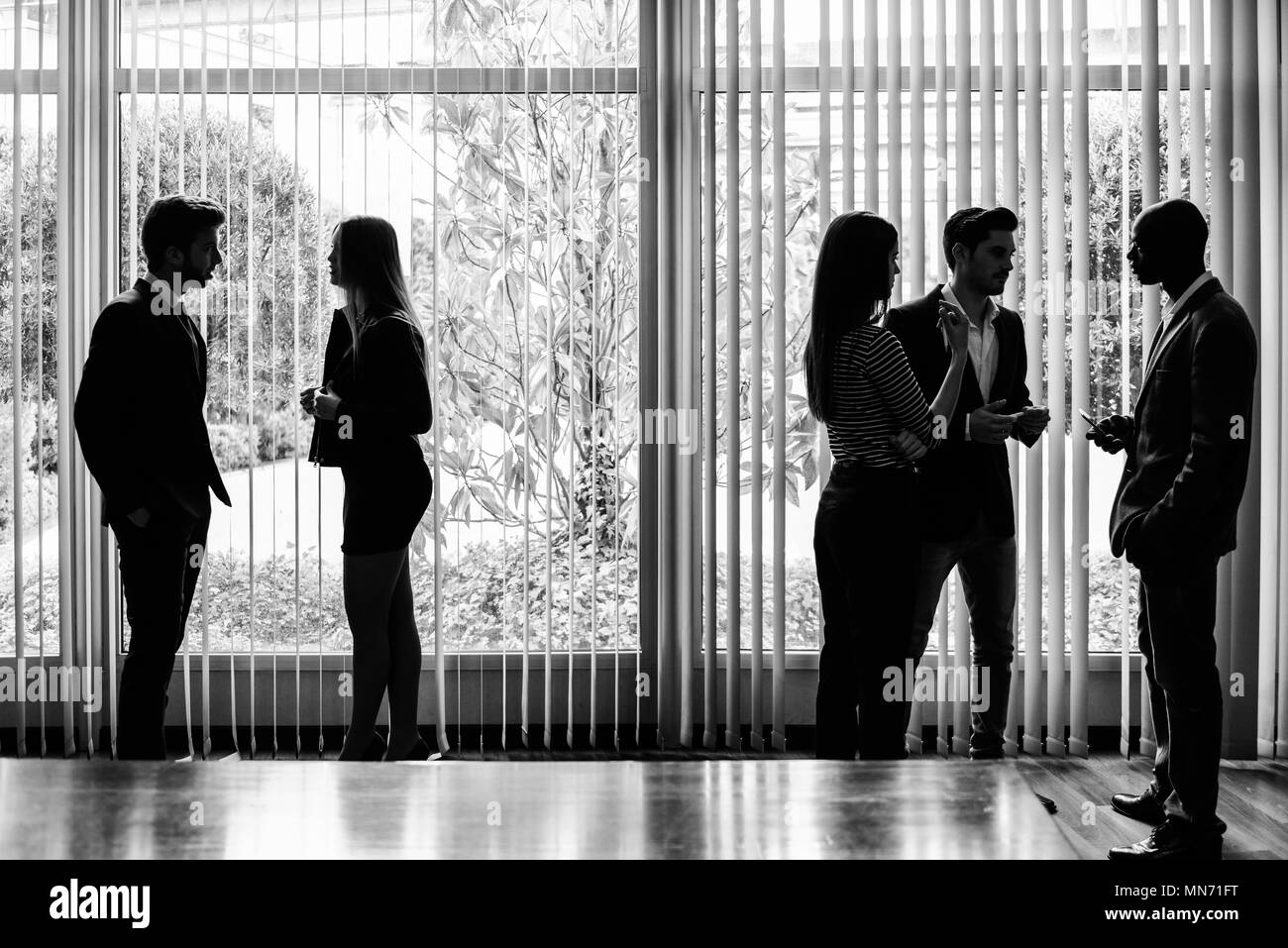 Several silhouettes of businesspeople interacting background business centrer Stock Photo