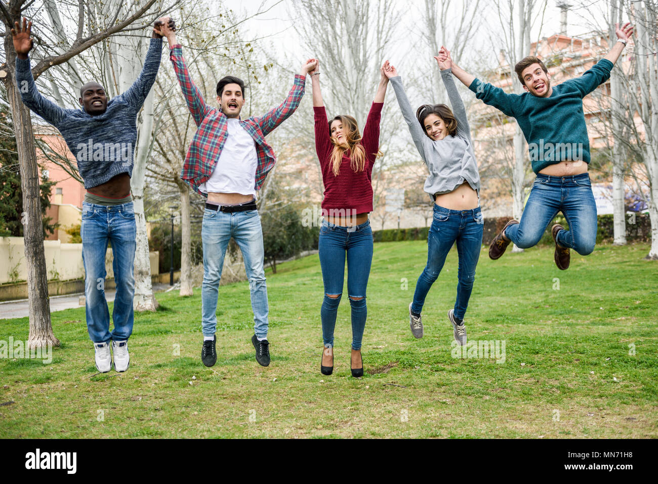 Group of multi-ethnic young people jumping together outdoors Stock ...