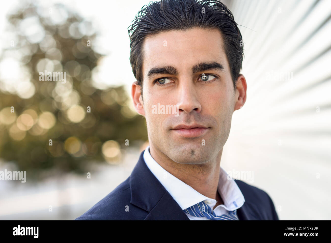Close-up of young businessman wearing blue suit and tie in urban ...