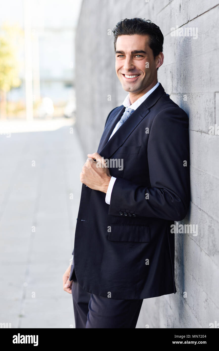 Young businessman wearing blue suit and tie in urban background. Man ...