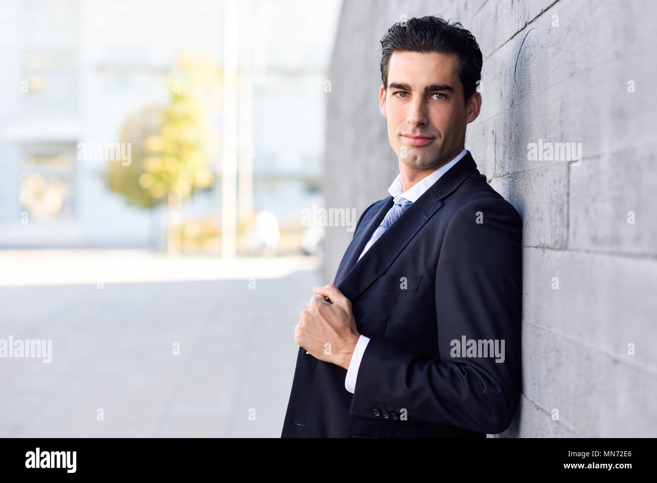 Businessman wearing blue suit and tie in urban background. Man with ...