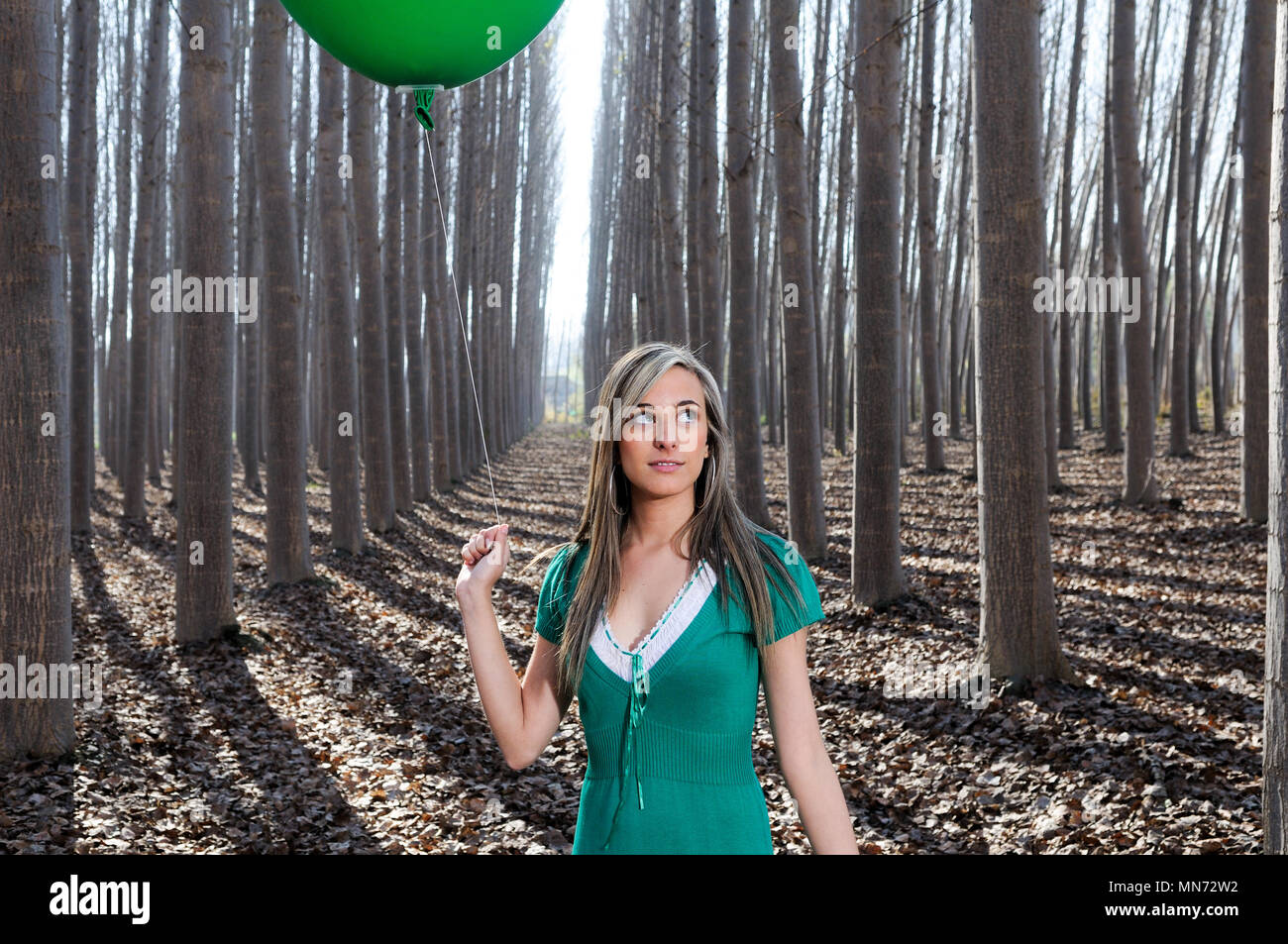 A girl with colorful striped stockings stands on the shadow of a tree - a  Royalty Free Stock Photo from Photocase