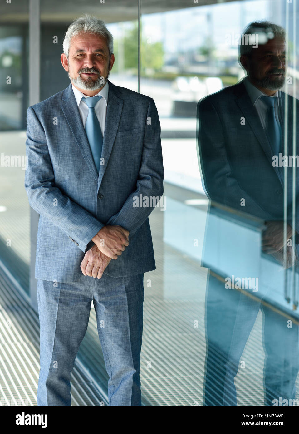 Portrait of a senior businessman with arms crossed outside of modern ...