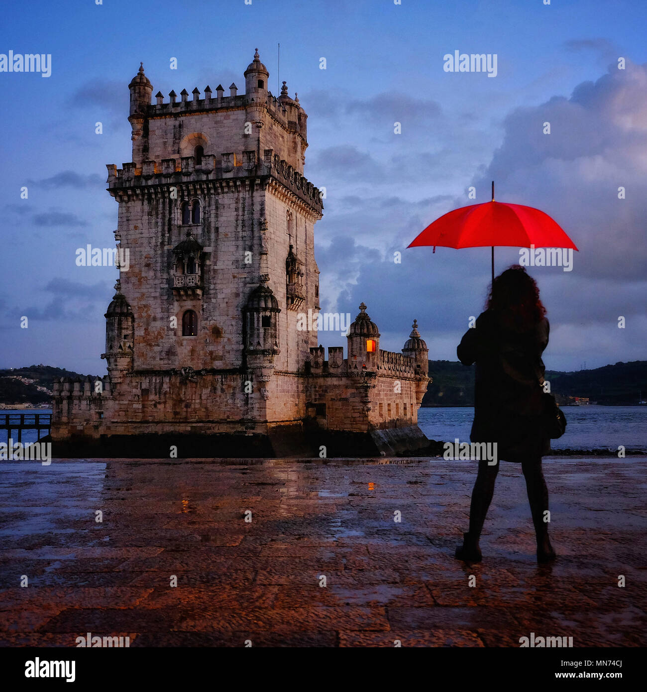 Woman holding red umbrella at Belem Tower, Lisbon Portugal Stock Photo