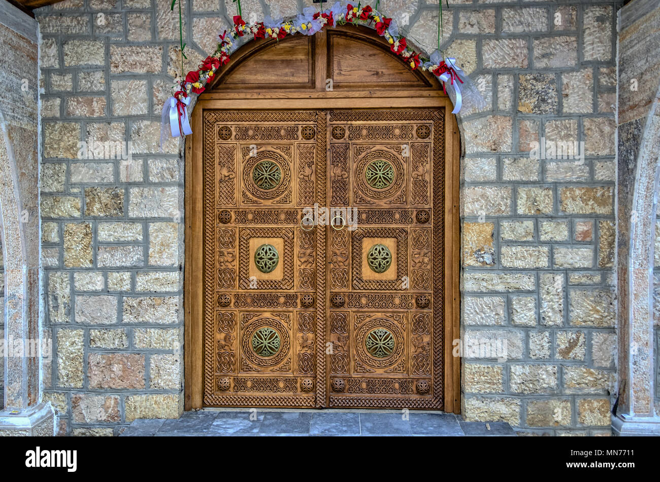 Very Ornate Engraved Wooden Brown Door of Eastern Orthodox Church / Chapel with Arch and Brass Embellishments - Kalista / Kalishta Monastery Macedonia Stock Photo