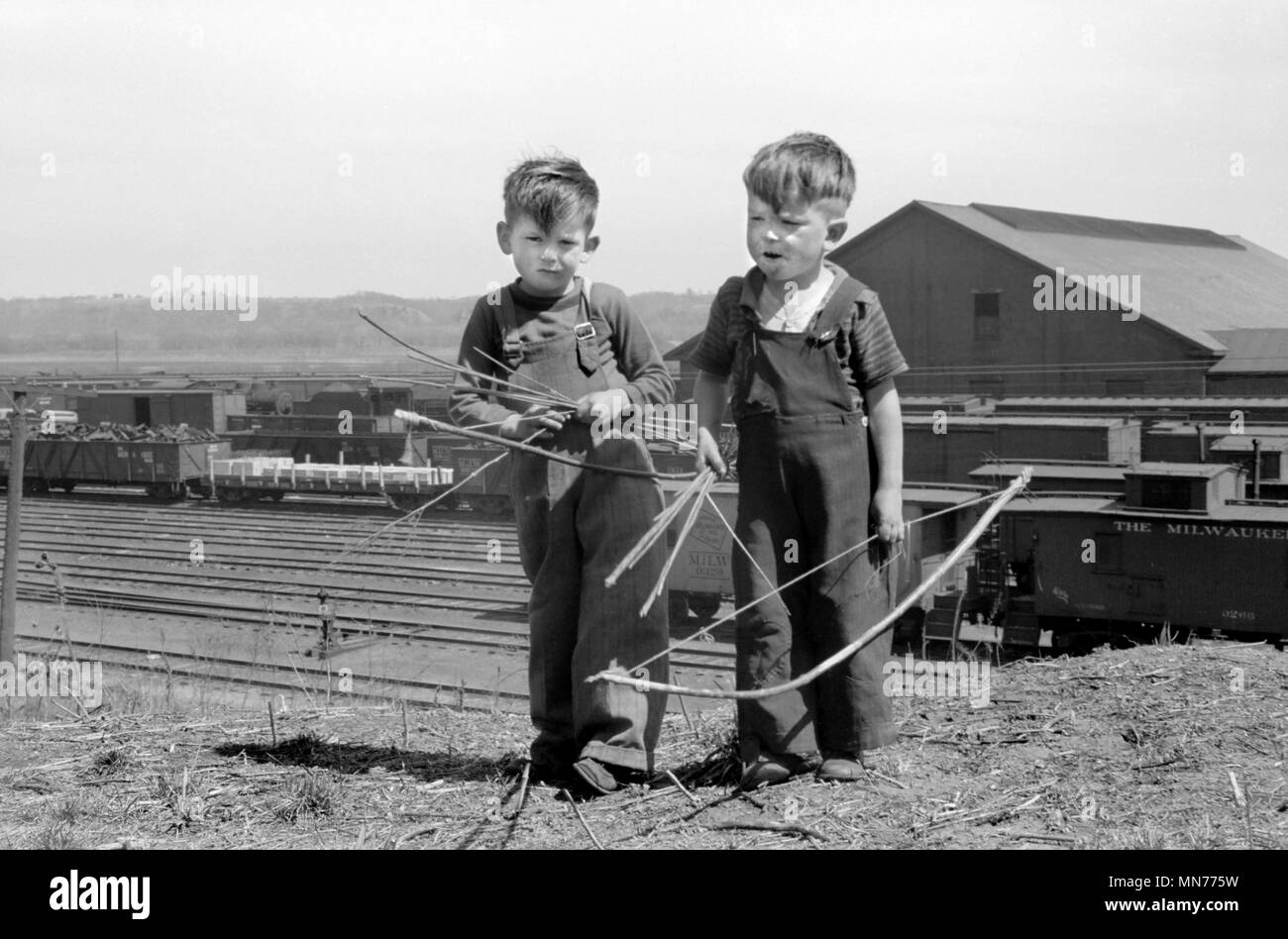 Two Young Boys Playing with Bows and Arrows near Railroad Yards, Dubuque, Iowa, USA, John Vachon for Farm Security Administration, April 1940 Stock Photo