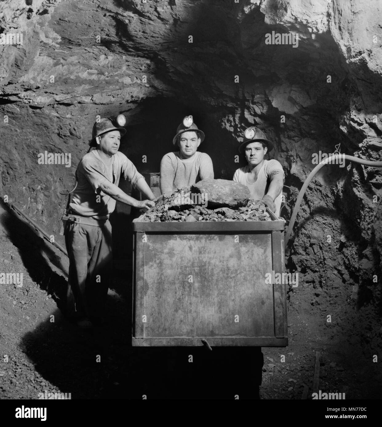 Three Miners Loading Mercury Ore into Mine Car by Hand, Quicksilver Mining Company, New Idria, California, USA, Andreas Feininger for Office of War Information, December 1942 Stock Photo