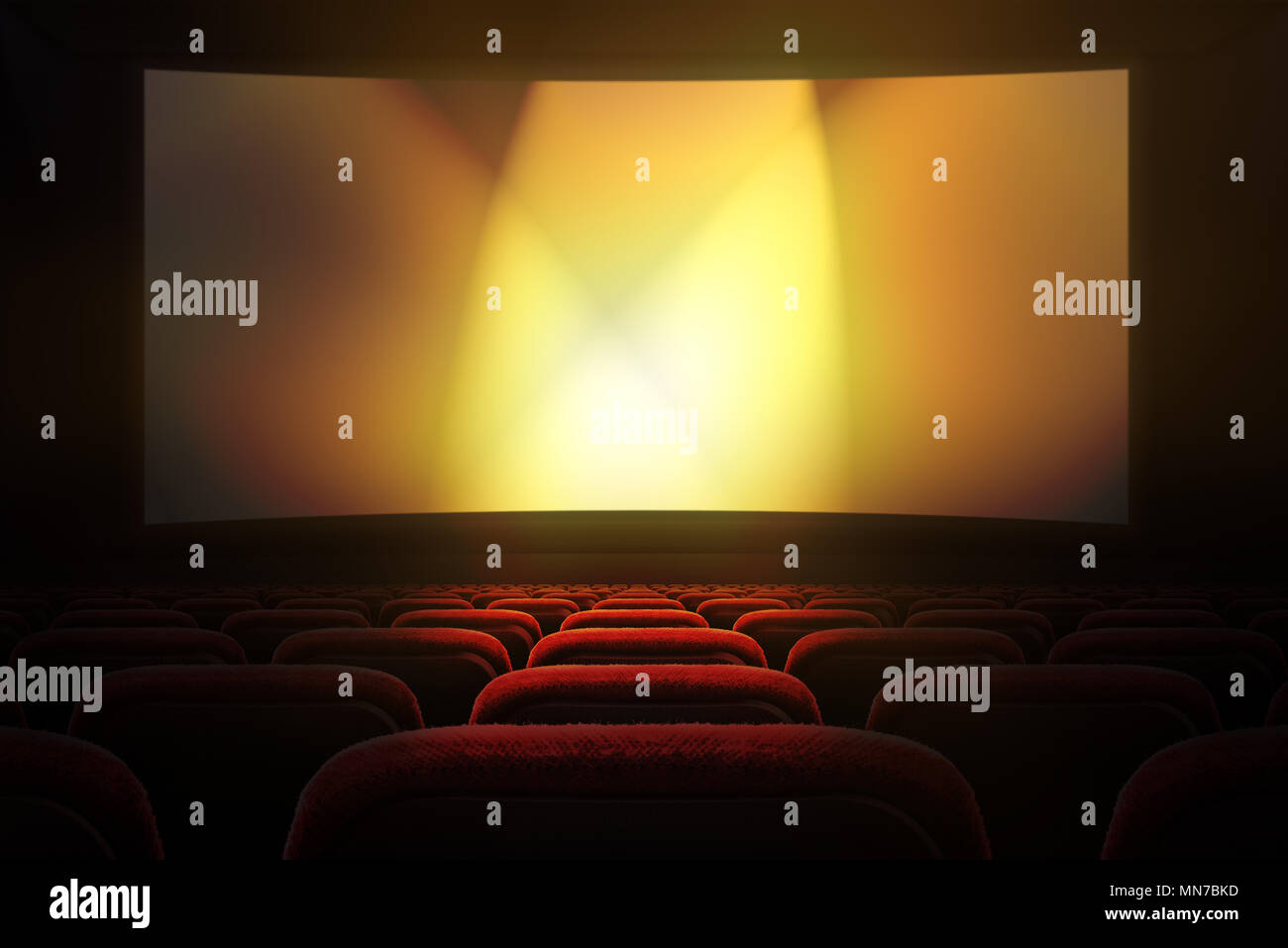 Movie theater with row of red seats and projection screen with golden lights in the background Stock Photo