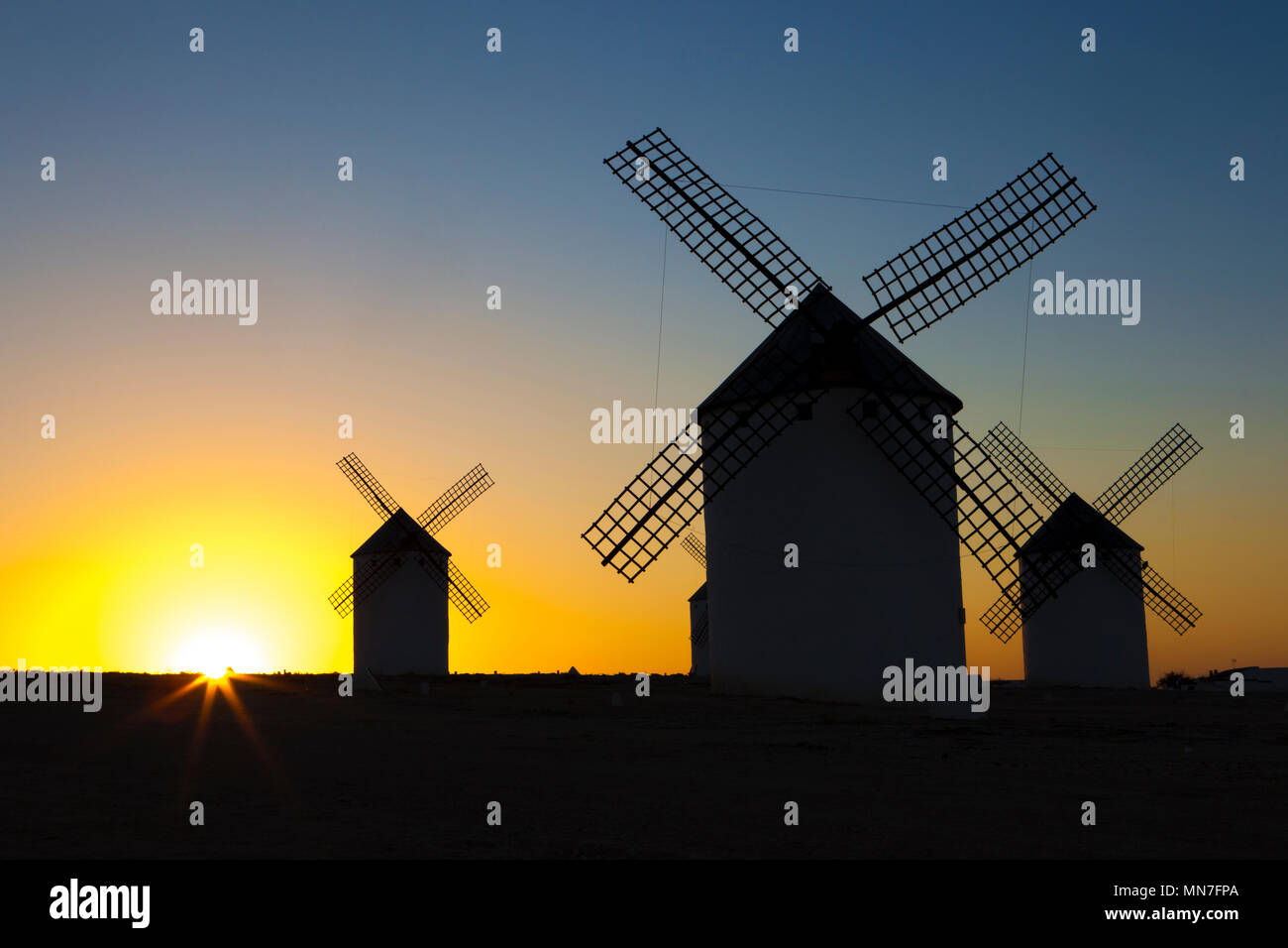 Silhouettes of traditional windmills at Campo de Criptana site, Spain. Rising backlighing Stock Photo
