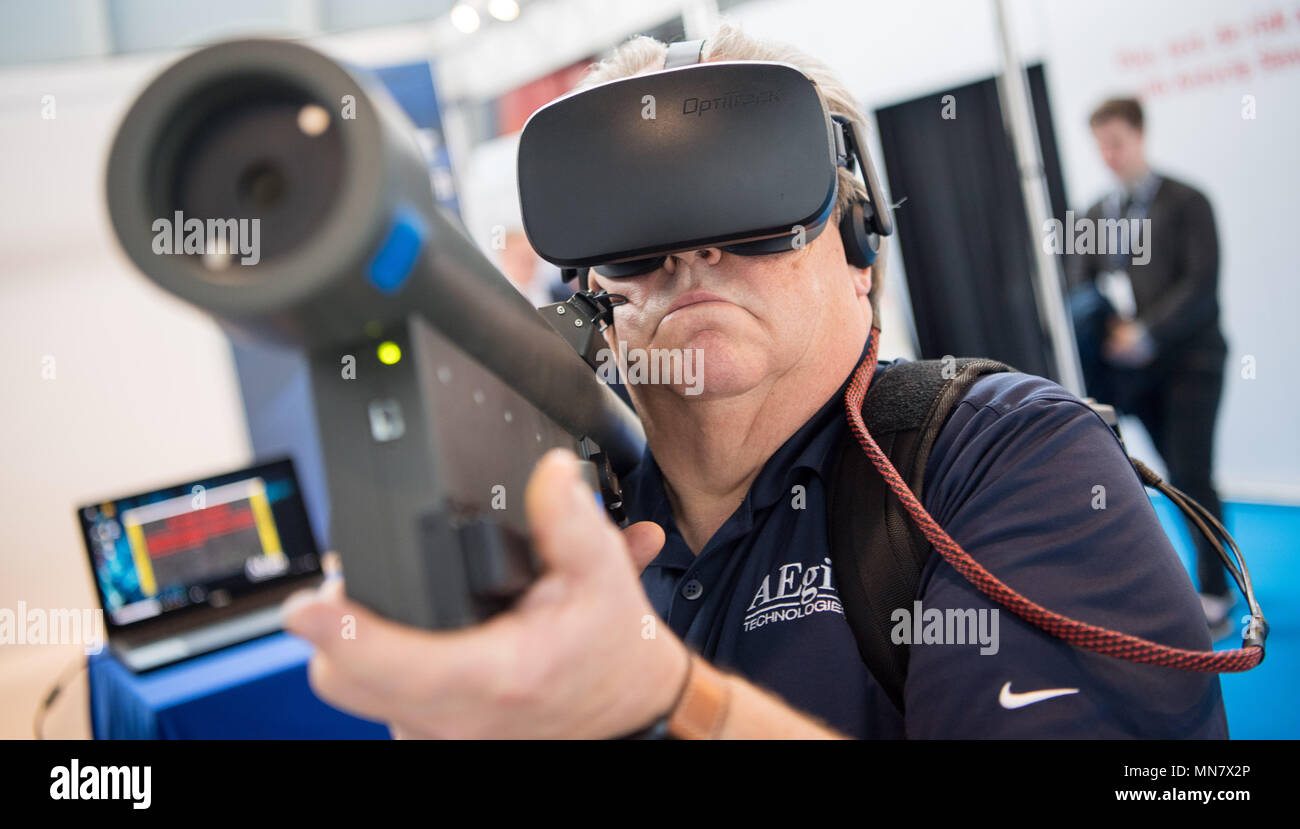 Stuttgart, Germany. 15th May, 2018. 15 May 2018, Germany, Stuttgart: An employee of the company Aegis uses the virtual reality simulator Virtual Stinger Trainer on the first day of the ITEC fair for military and weapons technology. The fair, which presents training and simulation software, among others, is running from 15 to 17 May. It is accompanied by demonstrations by opponents of weaponry. Photo: Sebastian Gollnow/dpa Credit: dpa picture alliance/Alamy Live News Stock Photo