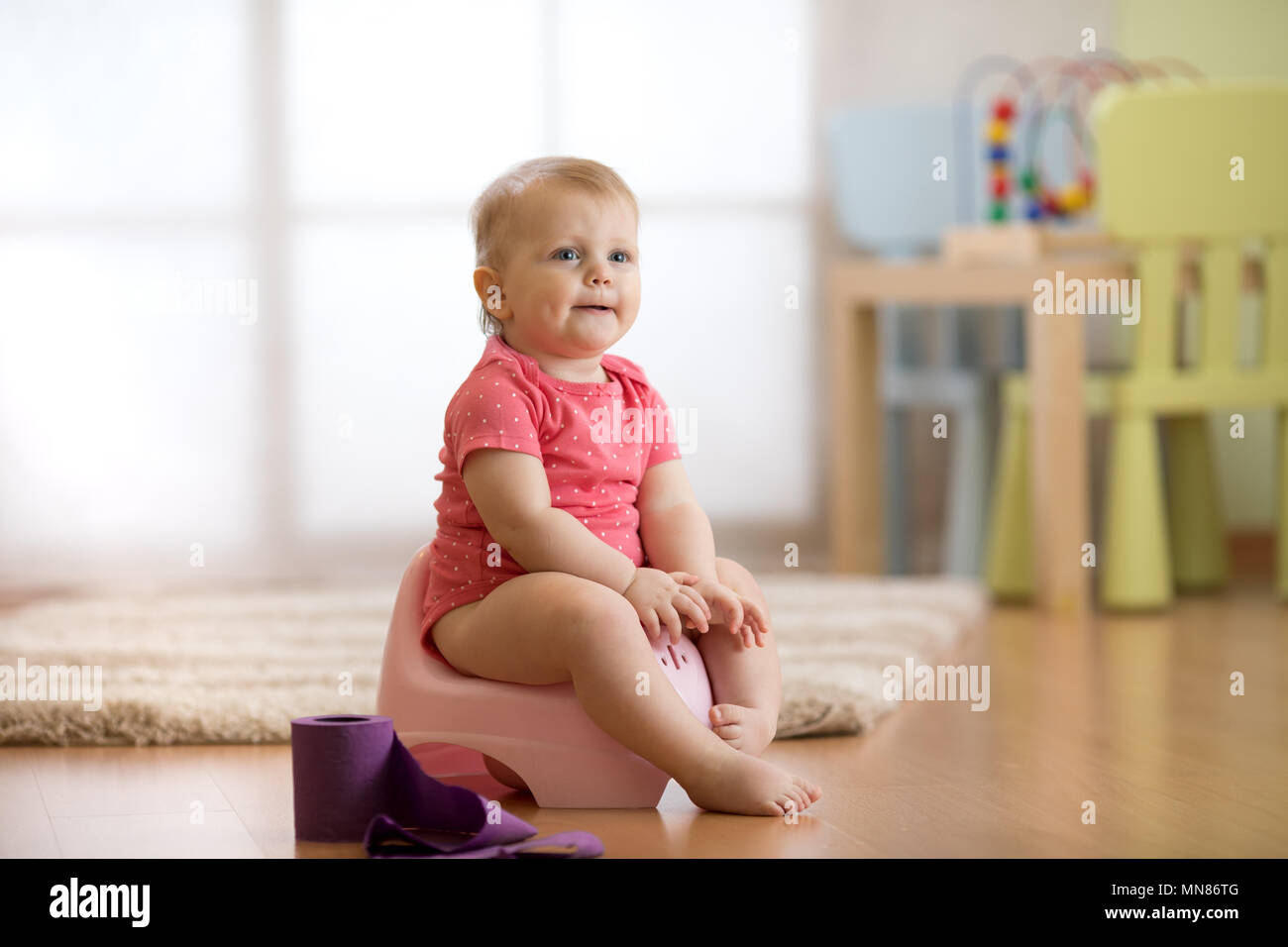 Baby learning how to use chamber pot Stock Photo Alamy