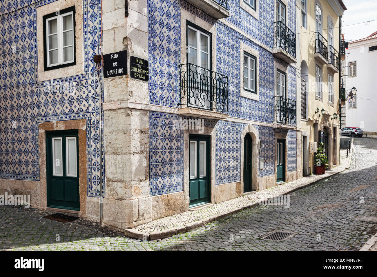 7 March 2018: Lisbon, Portugal - Traditional ceramic tiled house with wrought iron balconies on the corner of Rua de Loureiro and Rua de Guilherme Bra Stock Photo