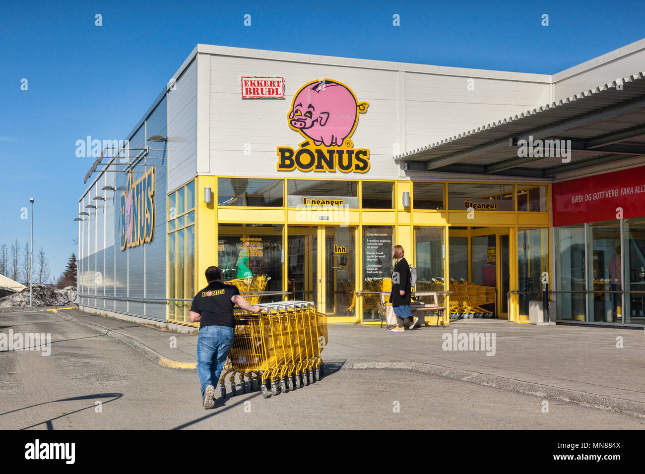 11 April 2018: Egilsstadir, East Iceland - Bonus Spermarket with worker pushing trolleys inside. Stock Photo