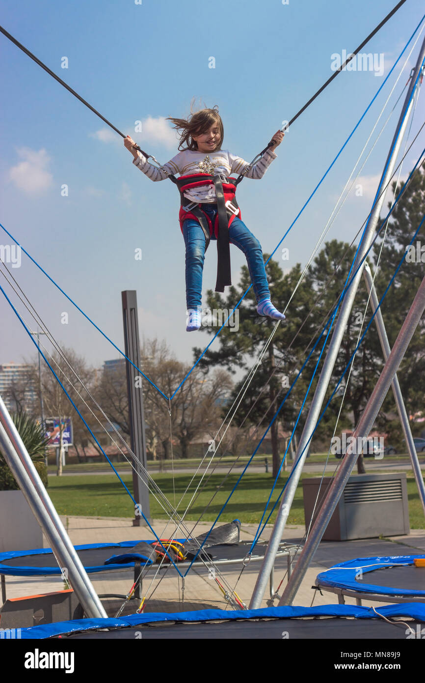 Little girl jumping on trampoline Stock Photo