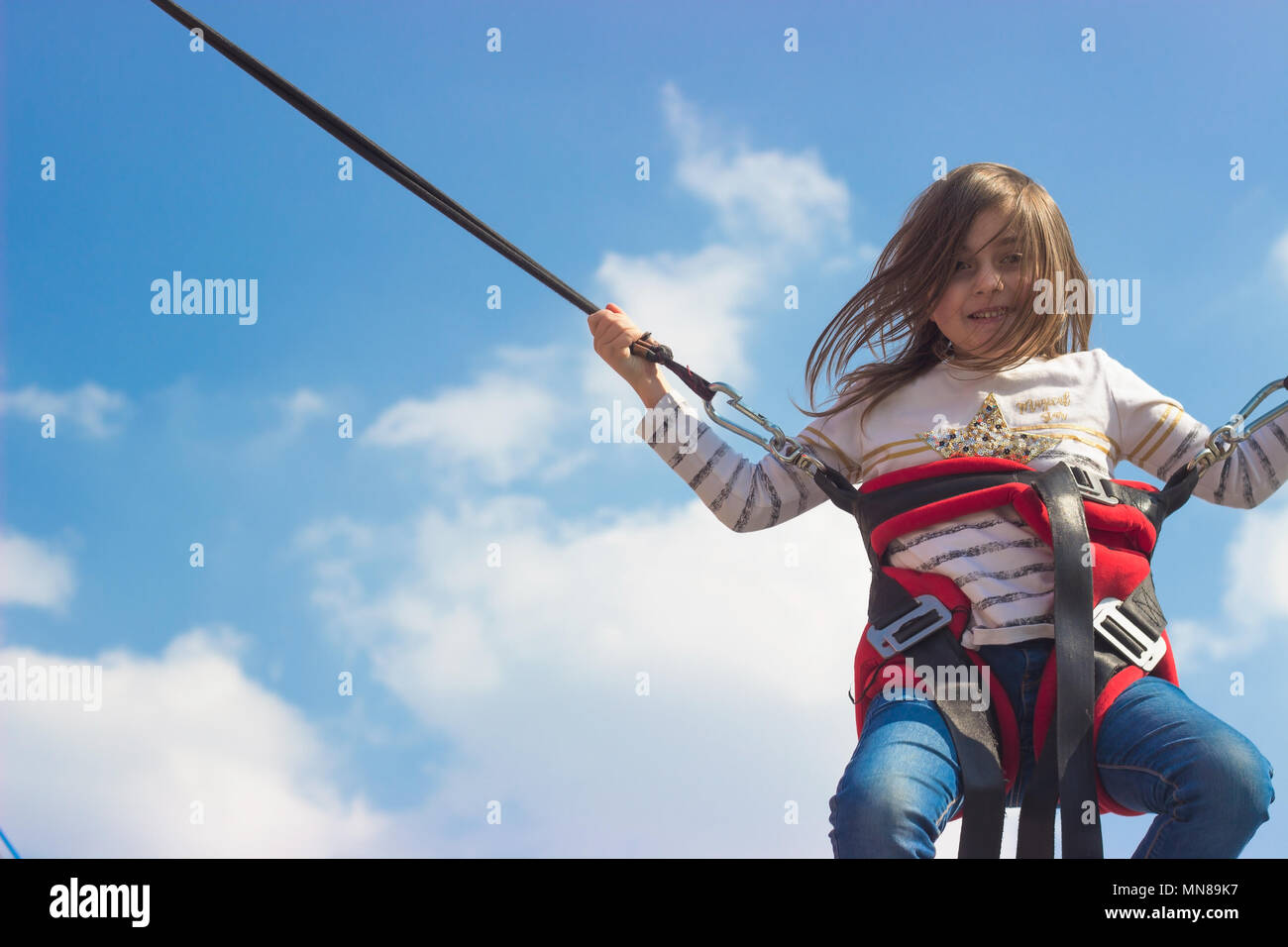 Little girl jumping on trampoline Stock Photo