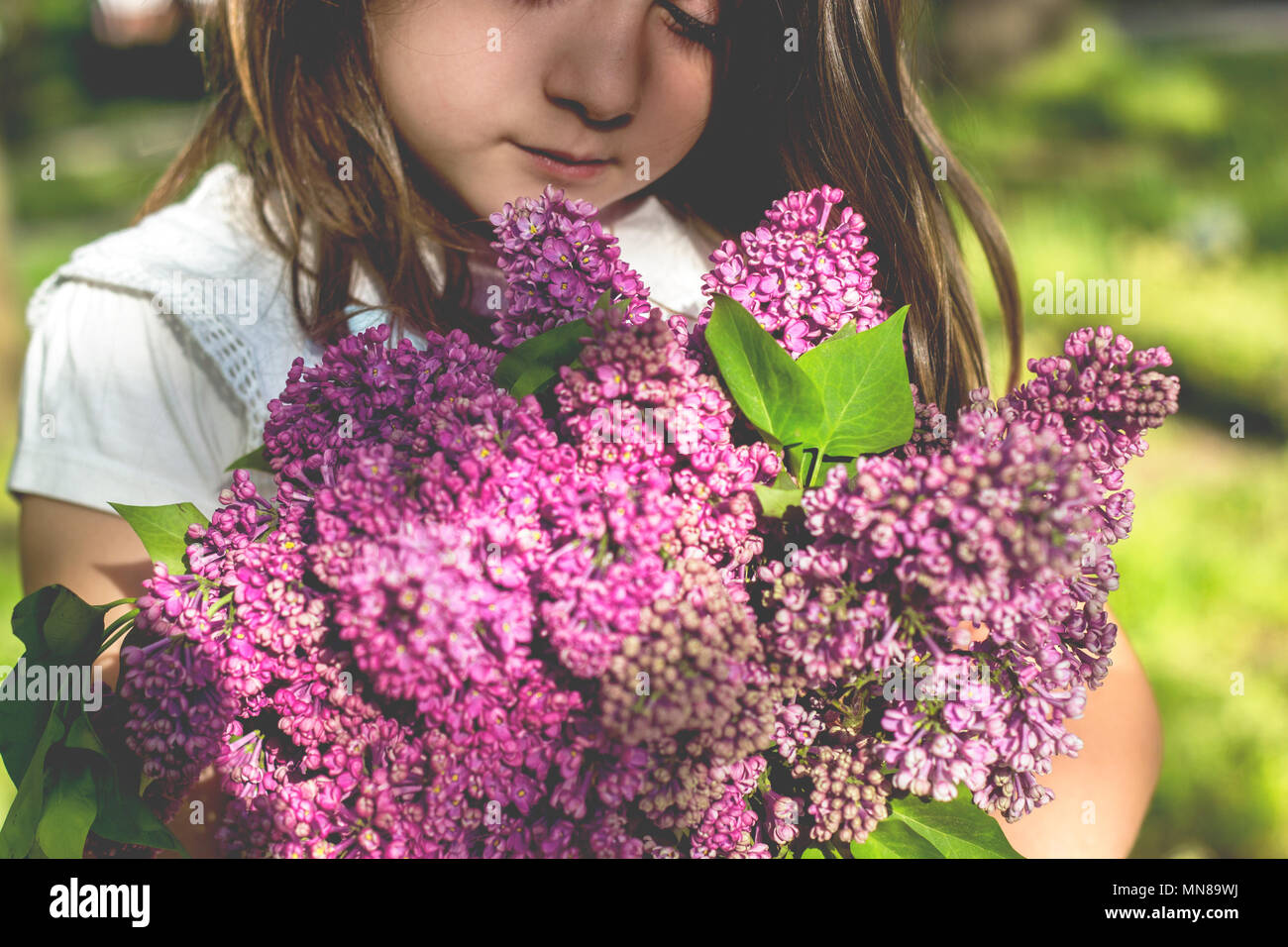 Little girl with bouquet of lilac in her hands Stock Photo - Alamy