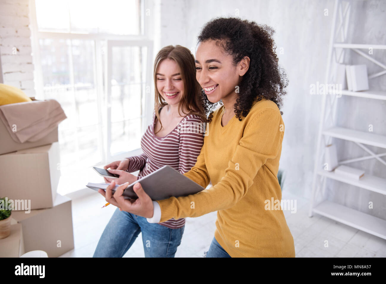 Pretty female students creating list of boxes Stock Photo