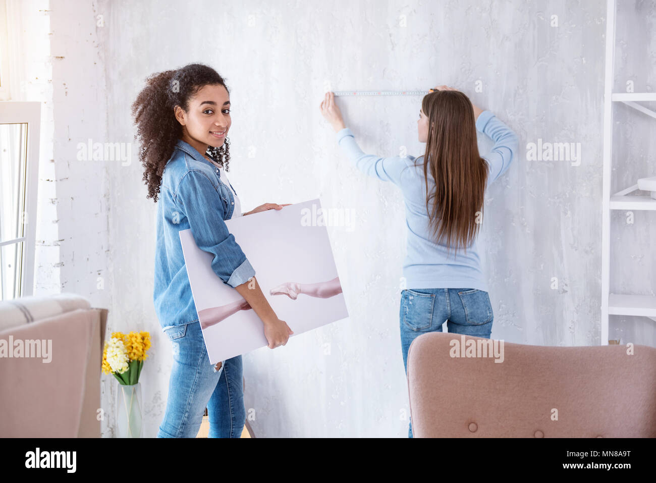 Cheerful curly-haired girl posing while holding picture Stock Photo