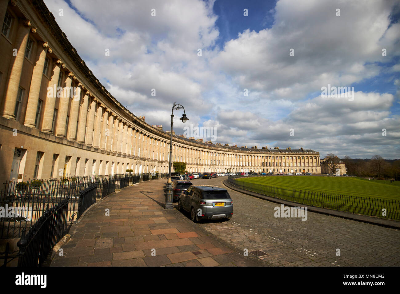 Royal Crescent residential road georgian houses footpath and pennant stone road with cars parked Bath England UK Stock Photo