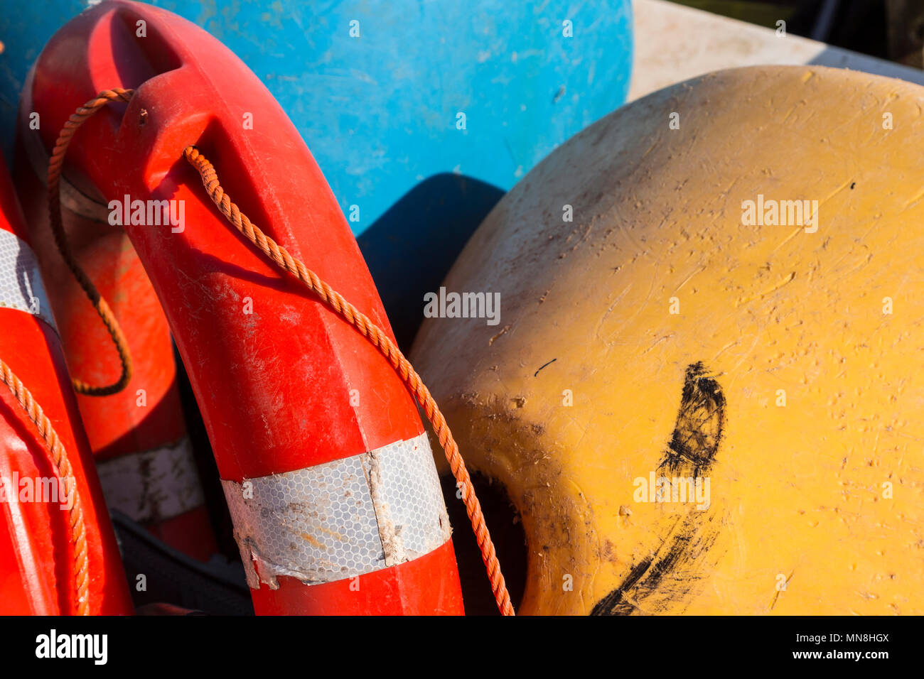 Lifebelt and buoys in colourful plastic at Moelfre on the coast of Anglesey, North Wales Stock Photo
