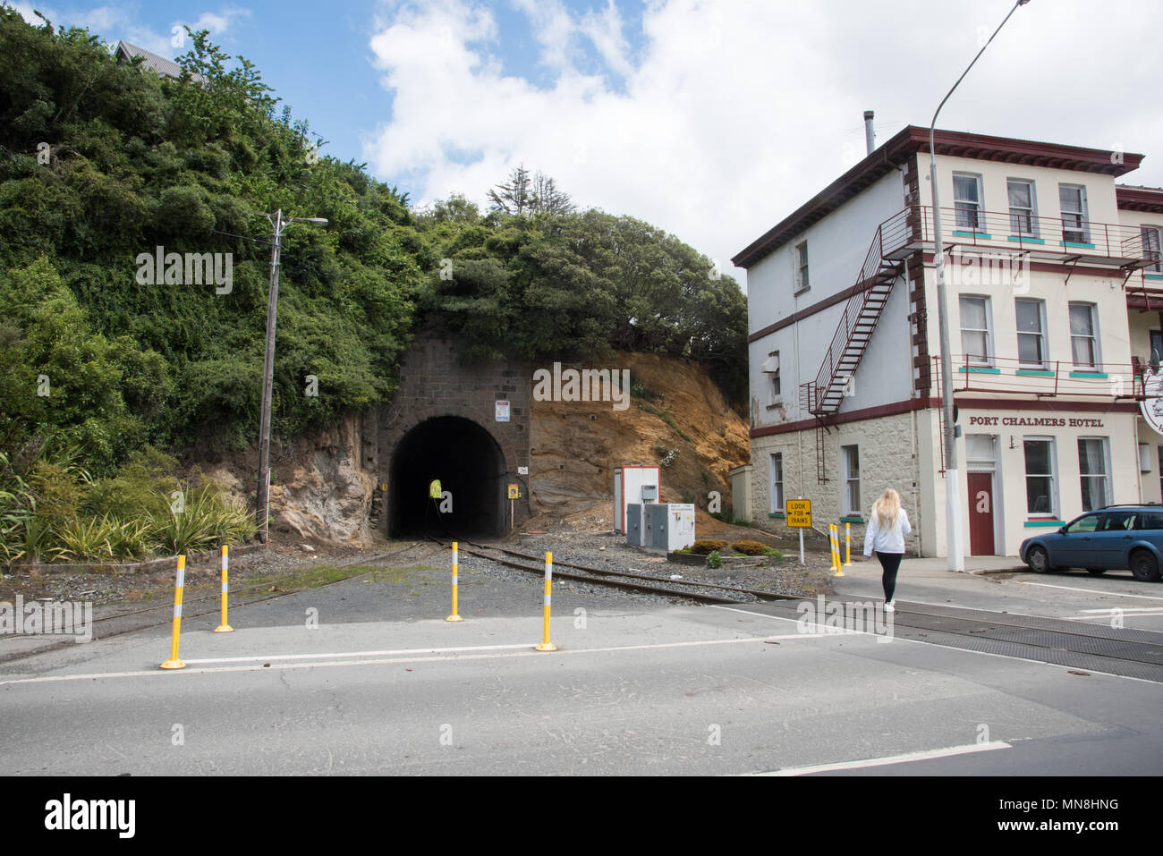 Dunedin, Otago, New Zealand-December 11,2016: Tourist walking to downtown Port Chalmers with railway tunnel and local hotel in Dunedin, New Zealand Stock Photo