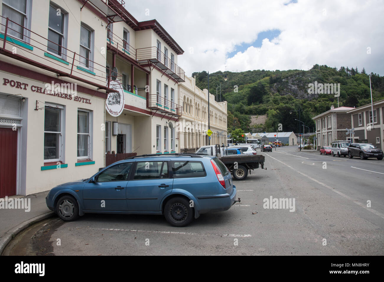 Dunedin, Otago, New Zealand-December 11,2016: Downtown Port Chalmers with hotel and other buildings, people and mountain view in Dunedin, New Zealand Stock Photo