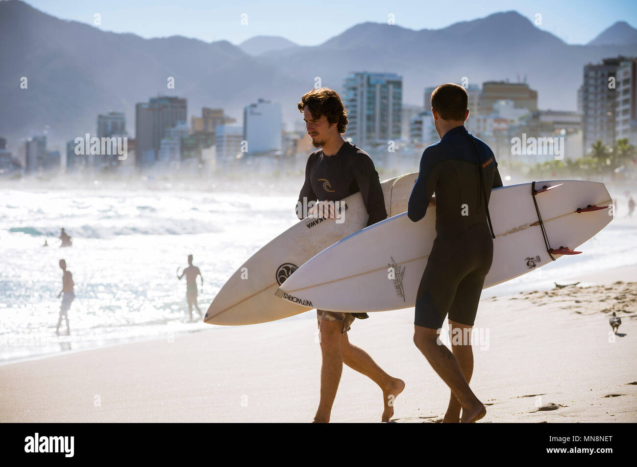 RIO DE JANEIRO - MARCH 20, 2017: Surfers stand on the beach before heading into the waves at the surf break at Arpoador. Stock Photo