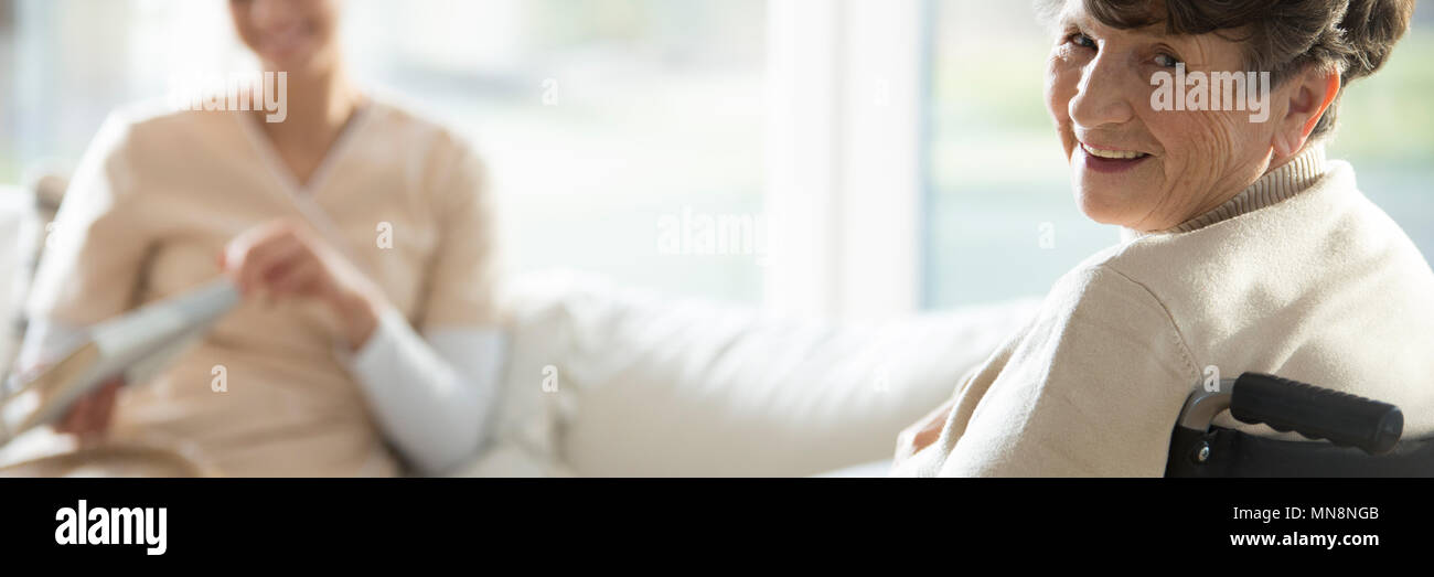 Happy disabled elderly woman enjoying time in a sanatorium Stock Photo