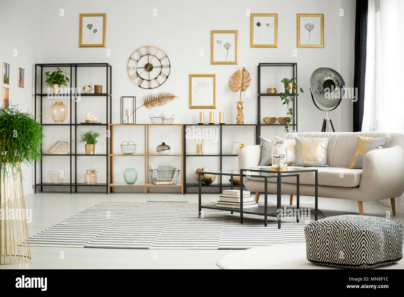 Pattern pouf and carpet in white living room interior with elegant sofa,  metal racks and black tables Stock Photo - Alamy