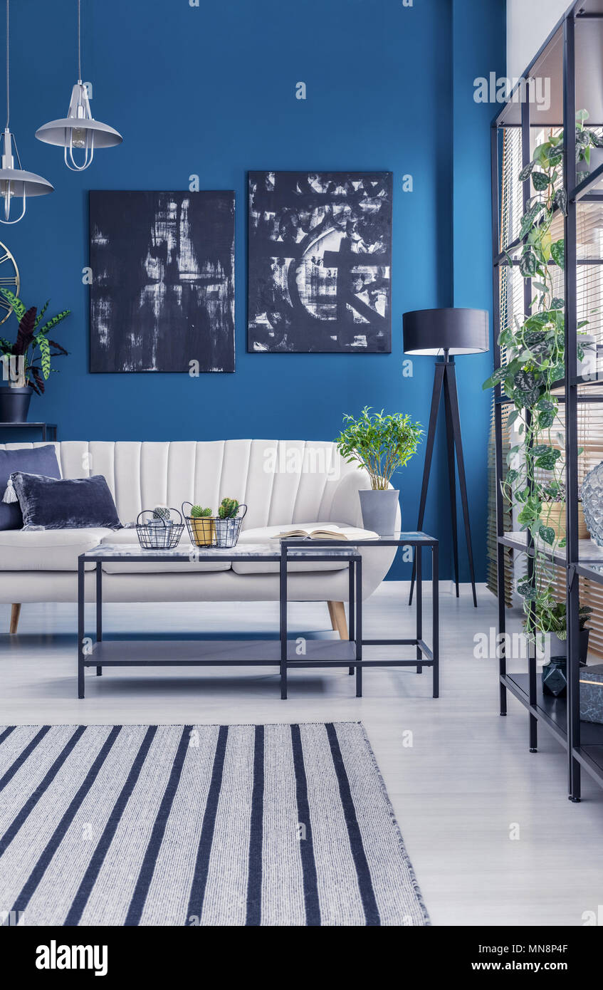 Black Industrial Racks And A Box Frame Coffee Table In A Blue Designer Living Room Interior With Artworks And Plants Stock Photo Alamy