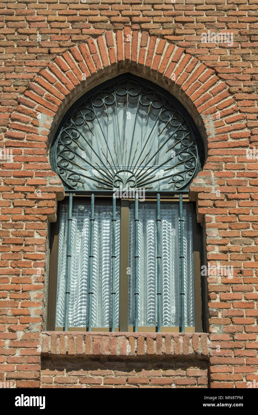 window with horseshoe arch in the brick exterior wall of a church in Madrid. Spain. Stock Photo