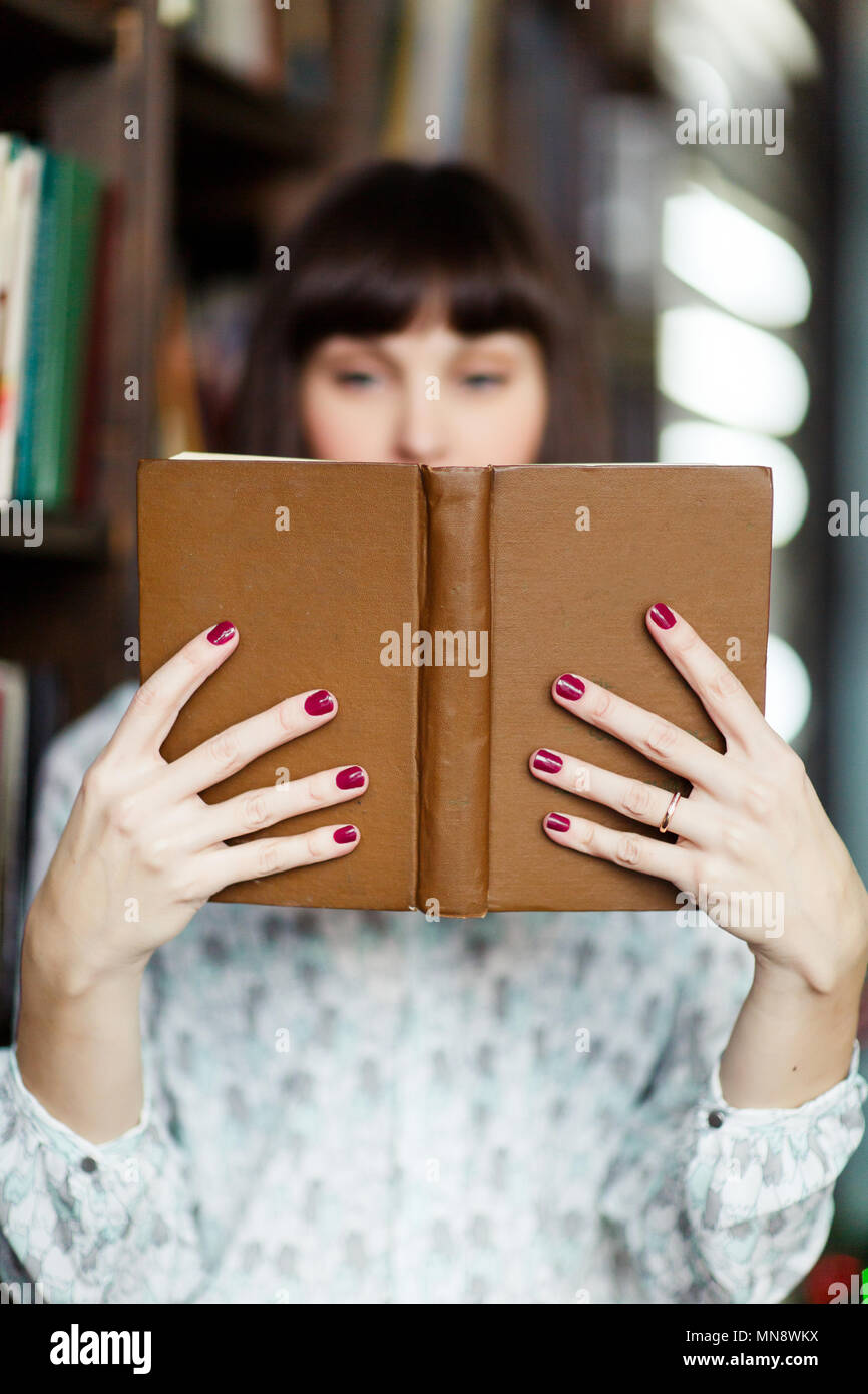 Image of young brunette with book in hand Stock Photo - Alamy