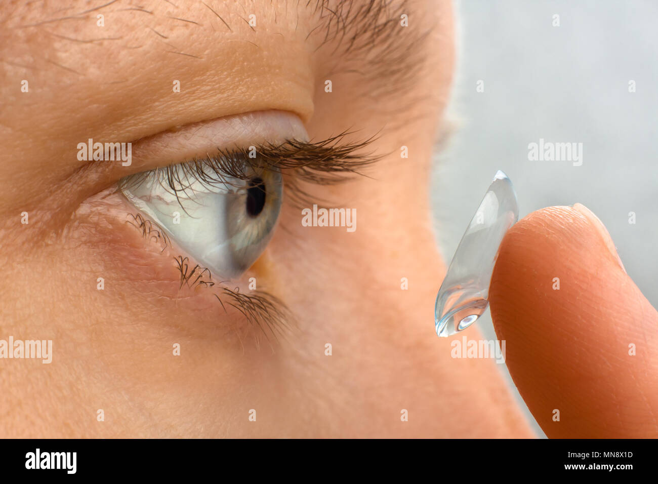 woman putting contact lens in her eye, closeup Stock Photo