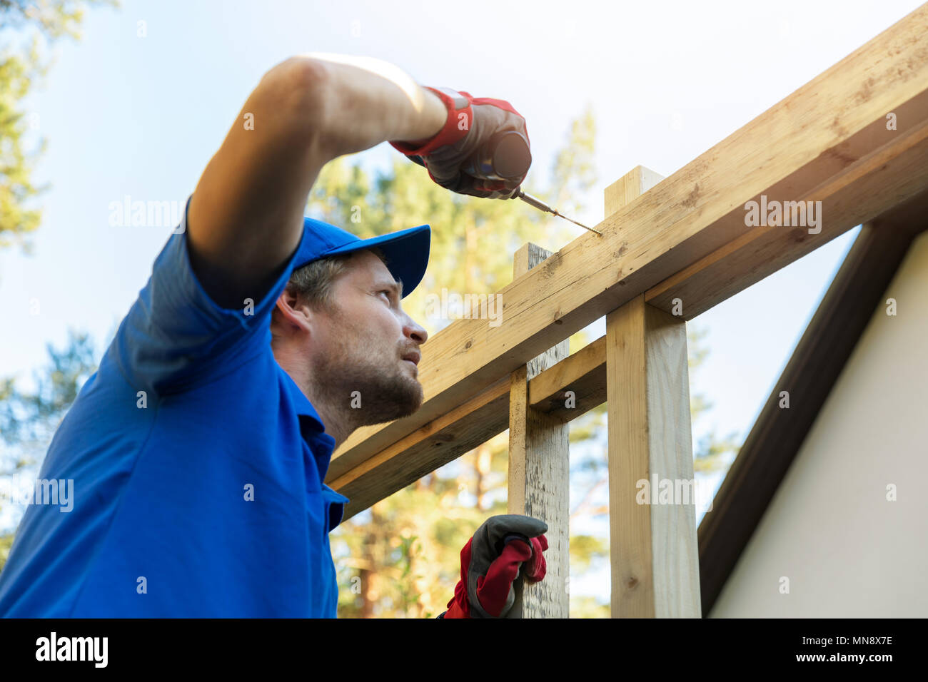 man is building a wooden house structure Stock Photo
