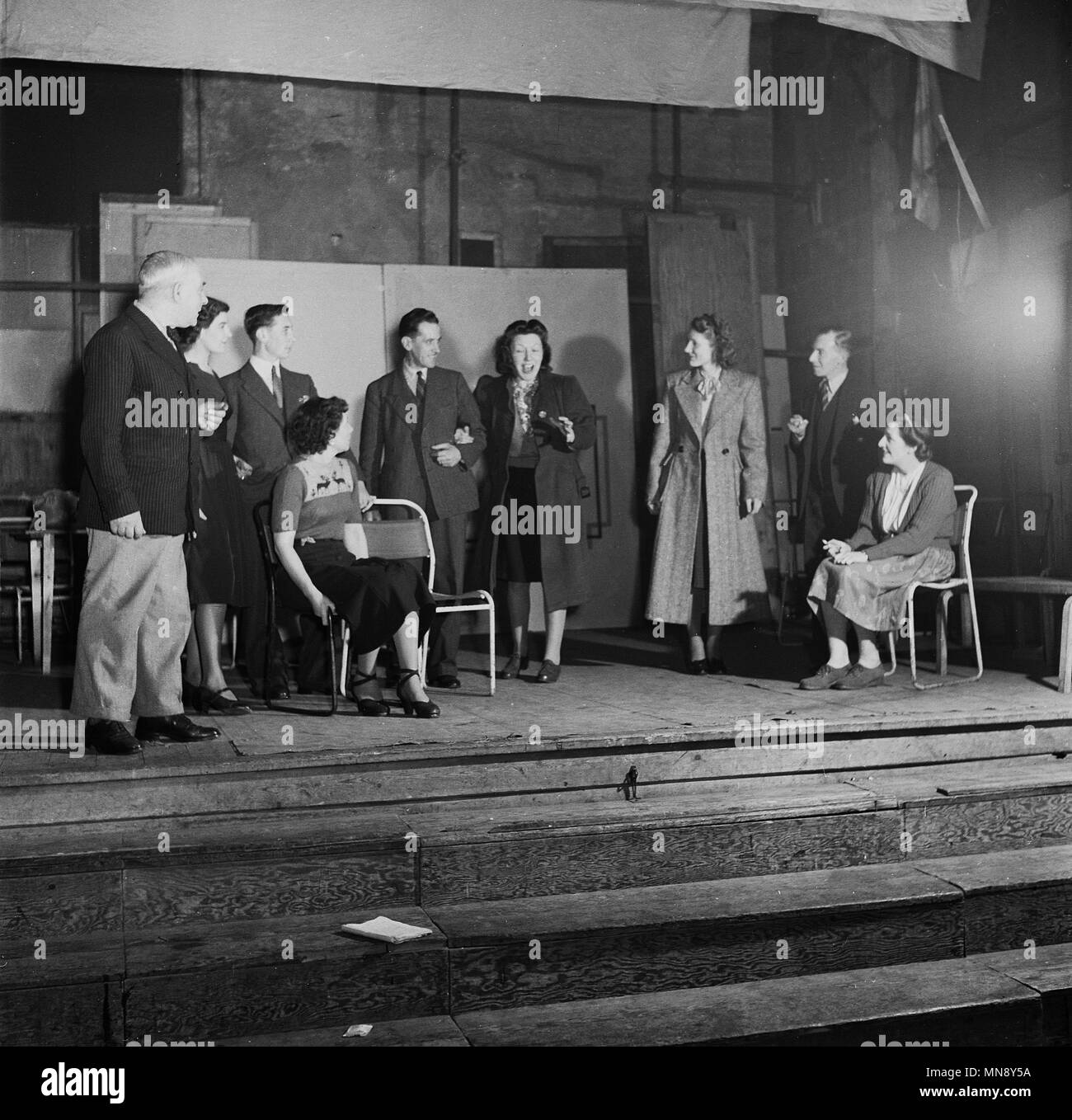 1950s, historical, amateur dramatics, ladies and gentlemen acting on together an old wooden stage during rehearsals of a play, England, UK. In this era, amateur theatre was popular and rehearsals would take place in all manner of venues including church halls and local sports clubs. Stock Photo