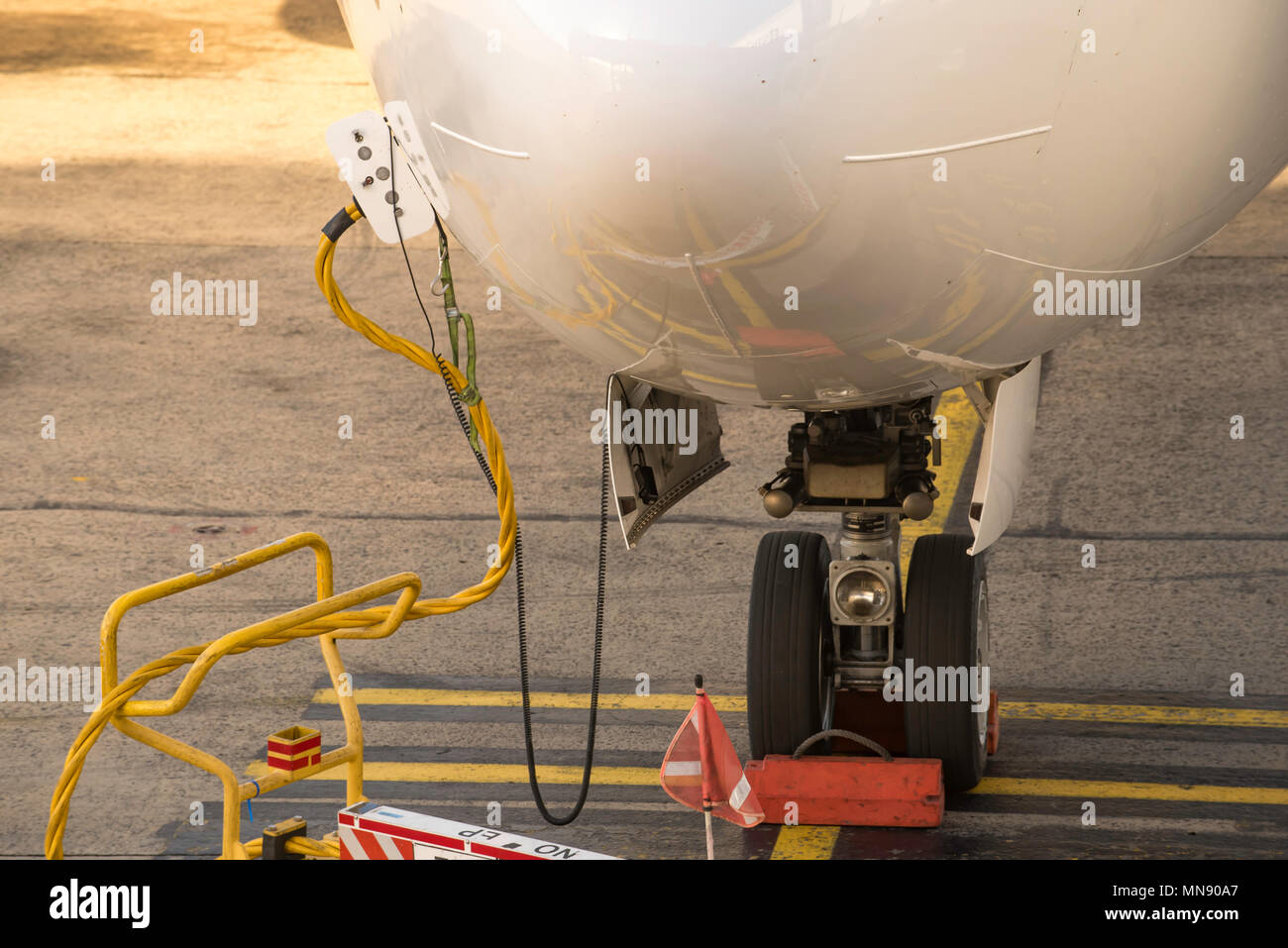 Close up of cables connected to a parked commercial aircraft at an airport in Australia Stock Photo