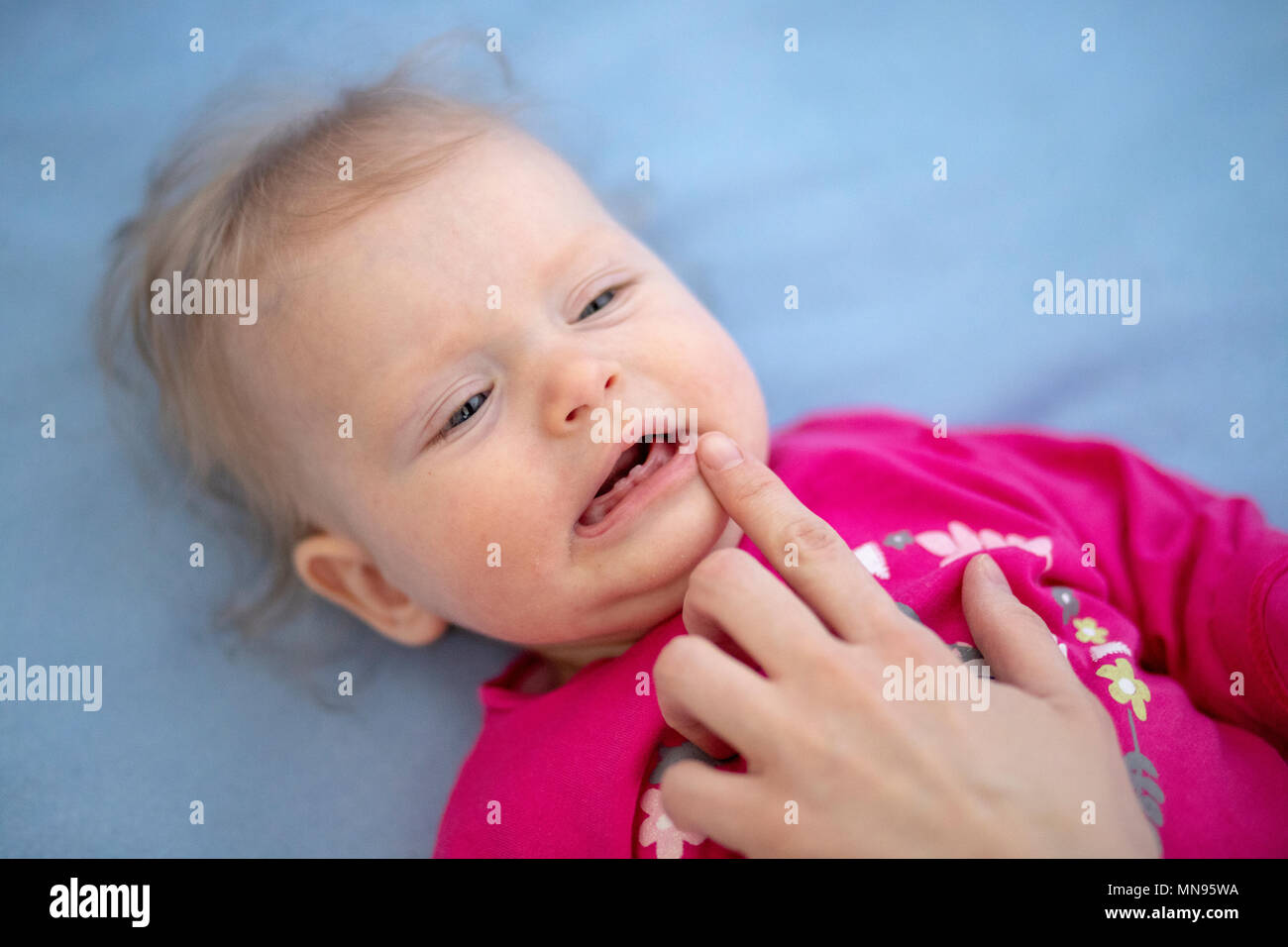Crying baby in pain examined by mother Stock Photo Alamy