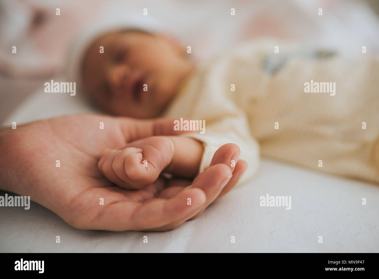 hand the sleeping baby in the hand of mother close-up. Stock Photo